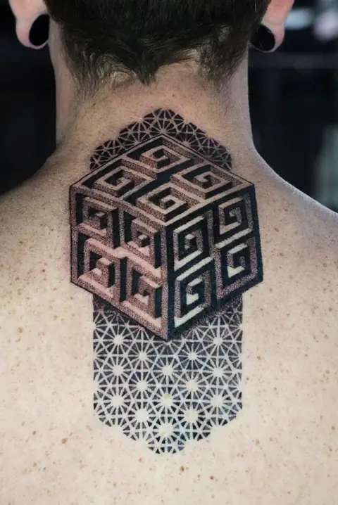 A geometric cube of meanders and a star pattern at the nape.