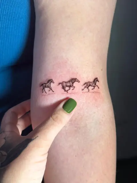 Three tiny horses in a gallop, drawn in a single quiet line.
