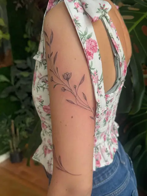 Wild stems wrapping the arm — thin, botanical, quiet.